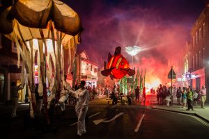 An illuminated performance through a town